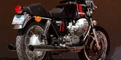 Colored photograph of Moto Guzzi motorcyle with black tank with red stripes.